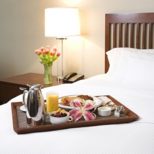 Breakfast tray on white bed.